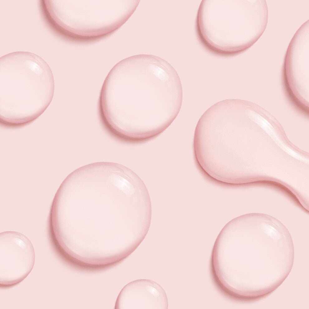 Gocce di prodotto skincare rosa con acido salicilico