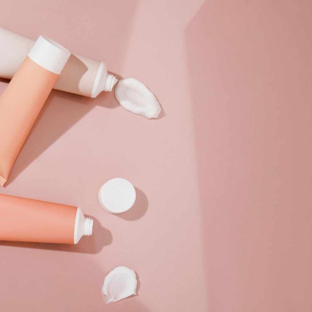 Prodotti skincare in tubi con crema versata, alcol nei cosmetici