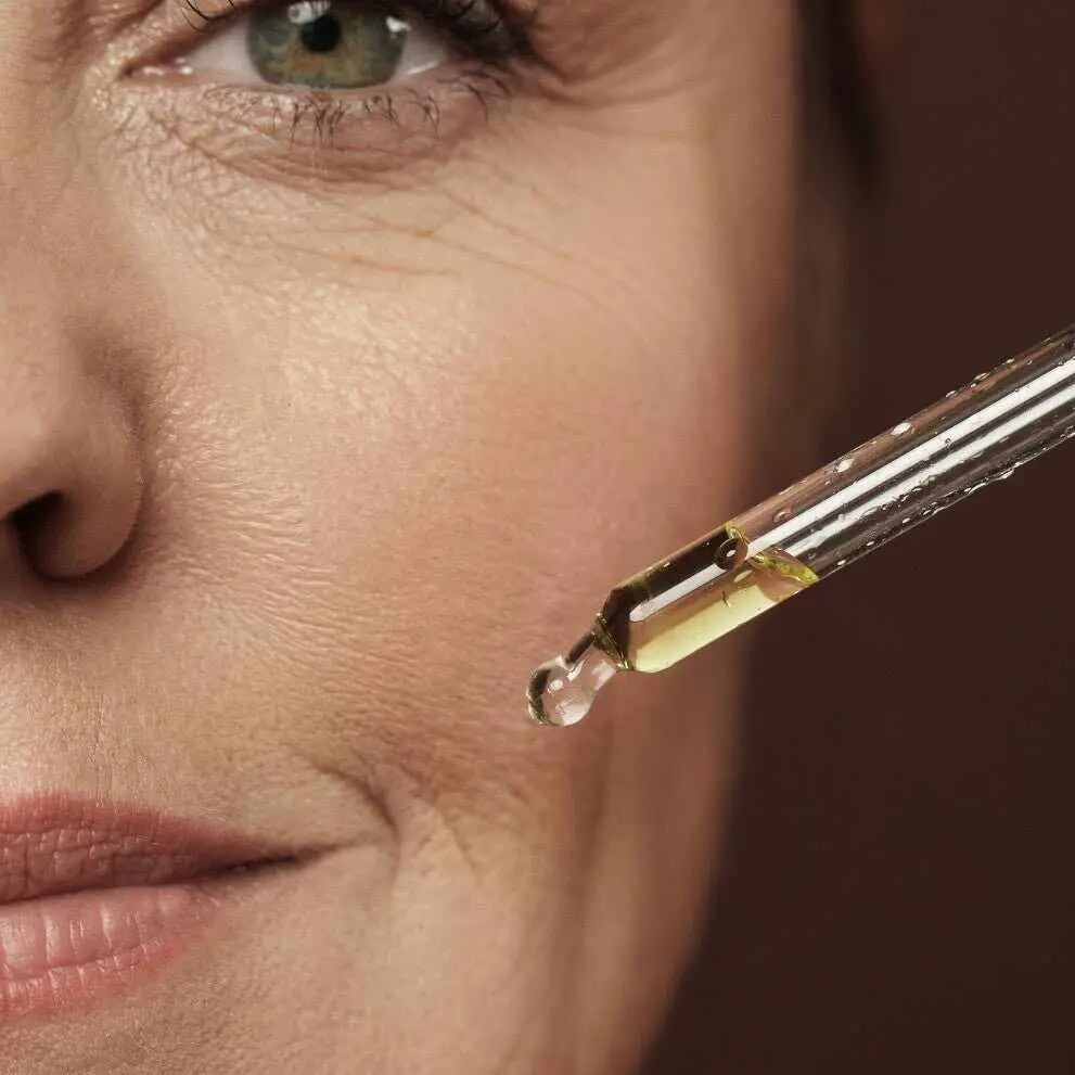 Goccia di siero antiossidante applicata sul viso di una donna