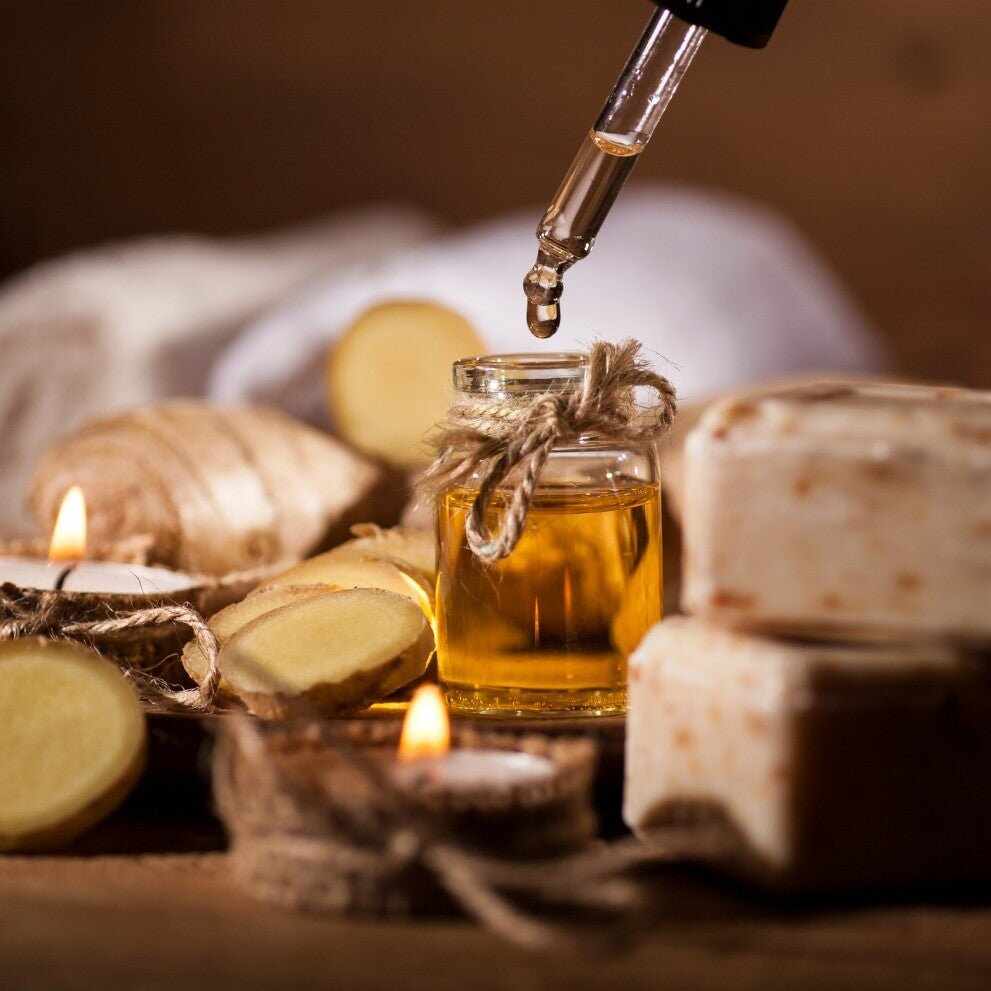 Goccia di olio vegetale dorato in bottiglia con zenzero, candele e saponi
