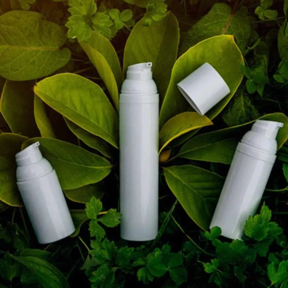 Tre bottiglie dispenser airless bianche per cosmetici skincare.