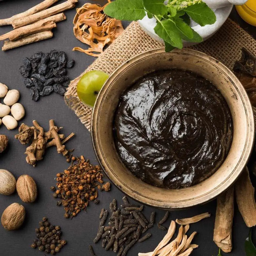 Ciotola di pasta erboristica ayurvedica densa con erbe e spezie essiccate