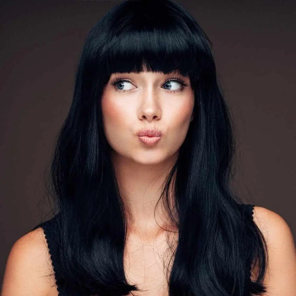 Donna con capelli neri lunghi e frangia, espressione imbronciata per henné nero