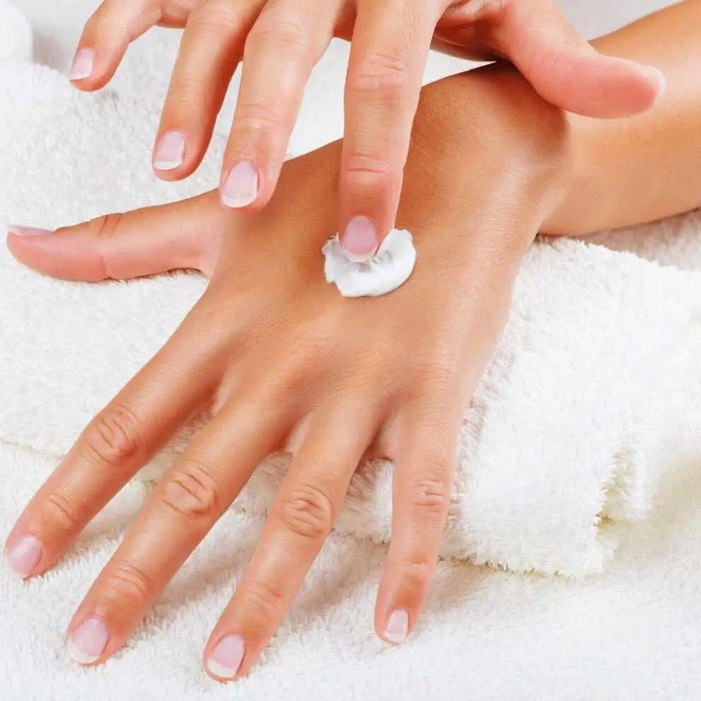 Mani screpolate: applicazione crema naturale sul dorso della mano
