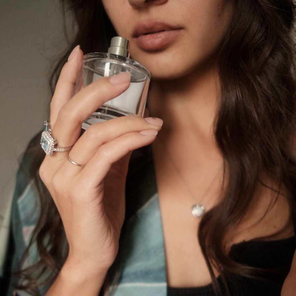 Bottiglia di profumo naturale in olio con tappo argento in mano