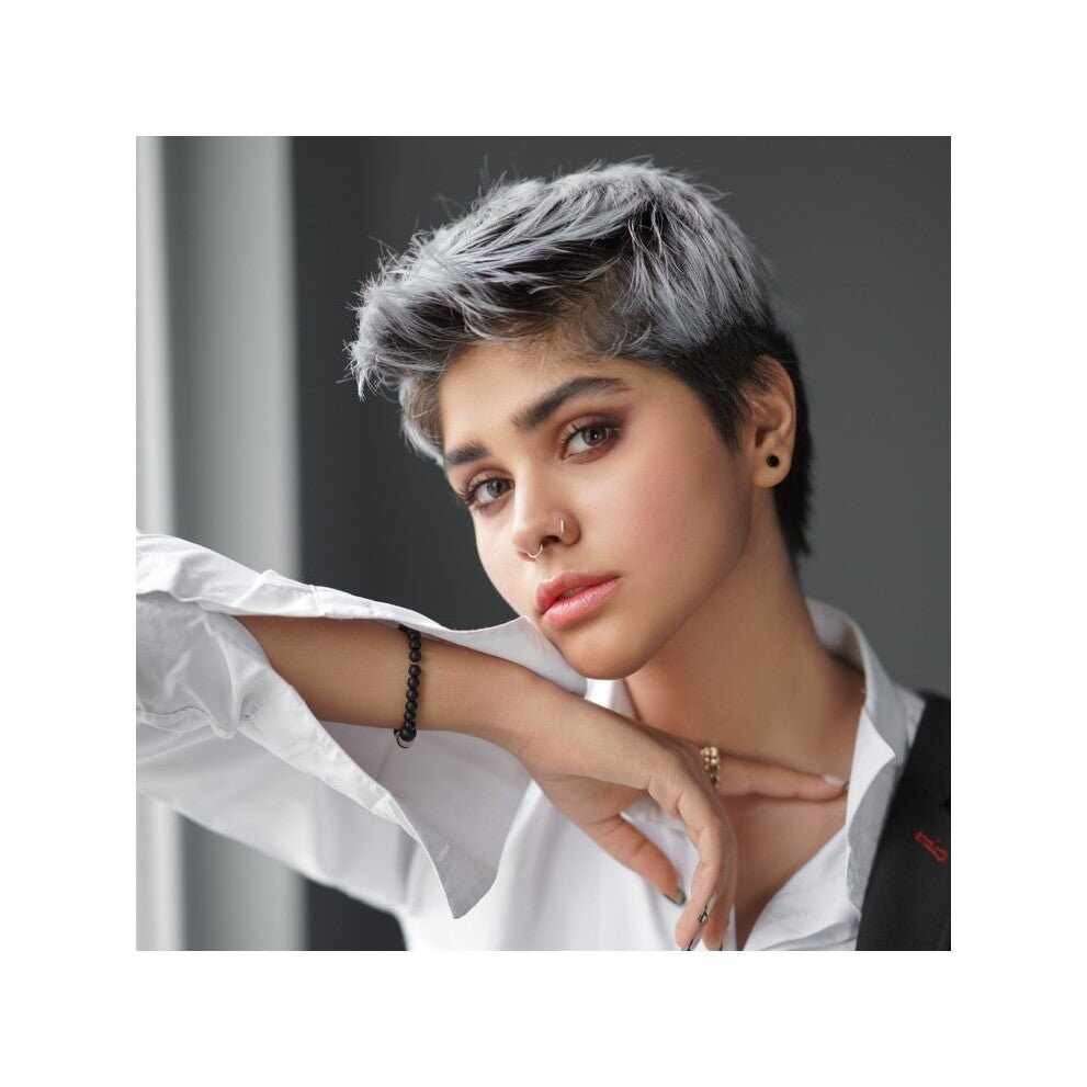 Persona con capelli corti scuri striati d’argento in routine bianchi