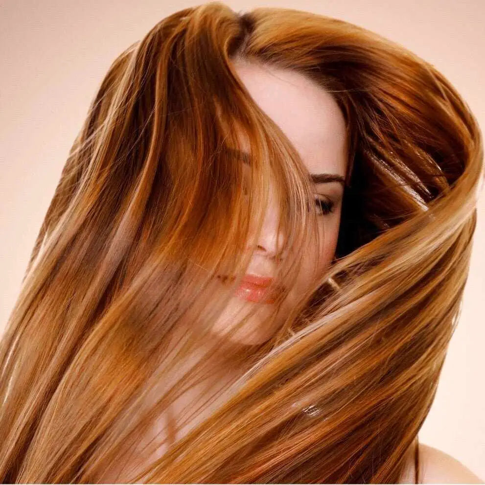 Donna con lunghi capelli castani ondulati per routine capelli sottili