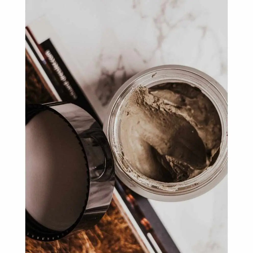 Barattolo aperto di maschera facciale scura e densa per detox pelle luminosa