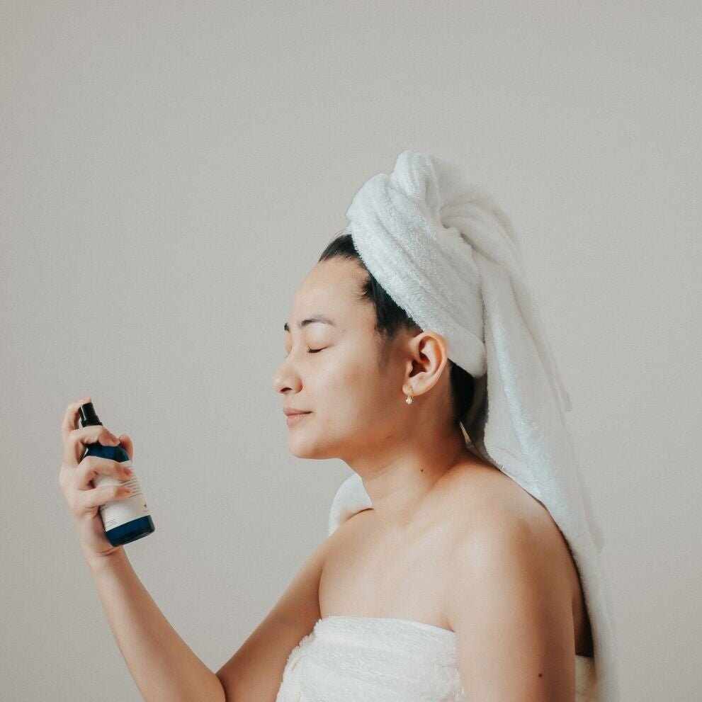 Donna applica tonico viso idratante per il 7 skin method