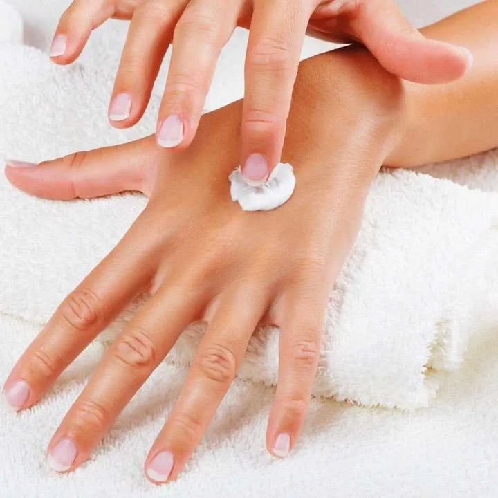 Mani screpolate: applicazione crema naturale sul dorso della mano
